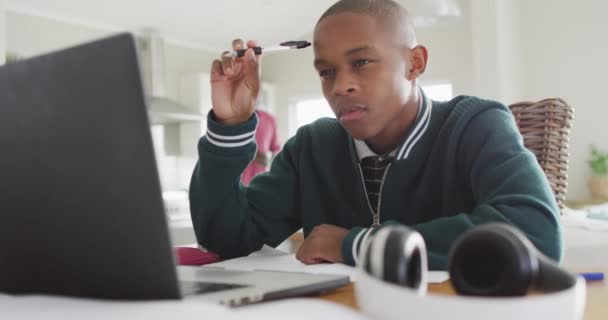 自宅でオンラインレッスンを受けているラップトップを持つアフリカ系アメリカ人の少年のビデオ 家庭の概念からの子供時代 教育と教育 — ストック動画