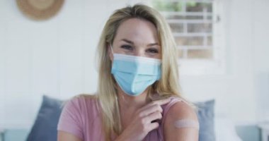 Kafkas 'lı mutlu bir kadın kolunda alçı olduğunu ve Coronavirus aşısı olduğunu gösteriyor. Covid 19 salgını sırasında sağlık ve yaşam tarzı. Noel kutlamaları, evde kutlama..