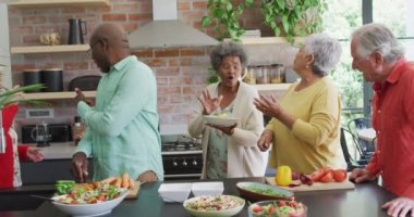 Mutfakta birlikte yemek pişiren bir grup mutlu kıdemli arkadaş. Evde arkadaşlarla sosyalleşmek..