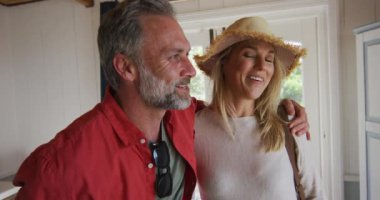 Mutlu kaküslü olgun çift otel odasına bavullarıyla geliyor. Boş zaman, seyahat ve tatiller.