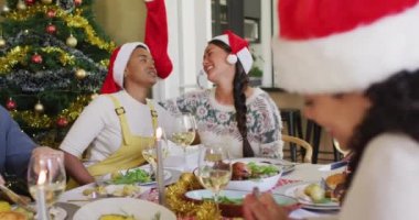 Noel 'de arkadaşlarıyla yemek yiyen iki farklı bayan arkadaş. Yılbaşı kutlamaları, evde arkadaşlarla kutlama..