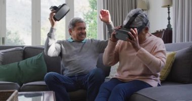 VR kulaklık takıp evde eğlenen mutlu son sınıf çifti. emeklilik hayatı teknolojiyle evde dinleniyor..