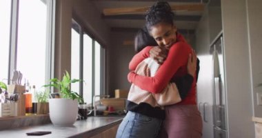 Video of happy biracial female friends embracing. Friendship, having fun and spending quality time together at home.
