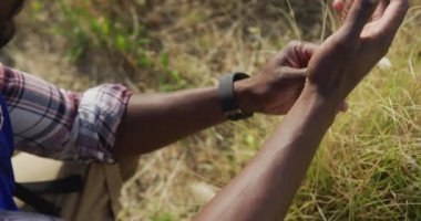 Afrika kökenli Amerikalı bir adam kırsalda buğdaya dokunup bakıyor. Fitness ve sağlıklı açık hava yaşam tarzı.