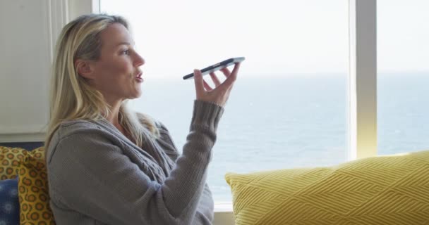 Щаслива Біла Зріла Жінка Дивиться Через Вікно Використовує Смартфон Насолоджуючись — стокове відео