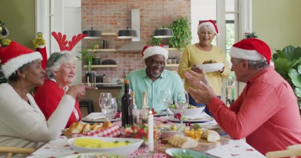 Fröhliche Runde Diverser Senioren Freunde Beim Gemeinsamen Essen Zur Weihnachtszeit — Stockvideo