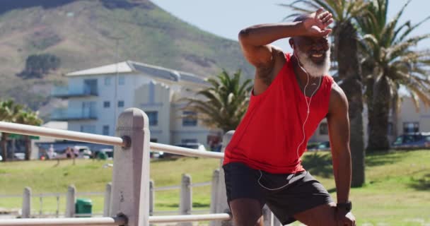 疲惫的资深非洲裔美国人 头戴耳机 从散步中休息一下 老年人健康的生活方式和体育概念 — 图库视频影像