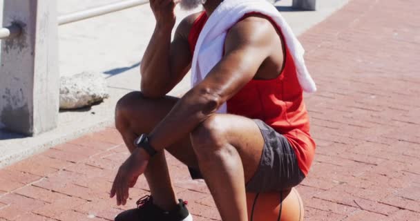 Homem Americano Africano Sênior Falando Smartphone Enquanto Senta Basquete Quadra — Vídeo de Stock