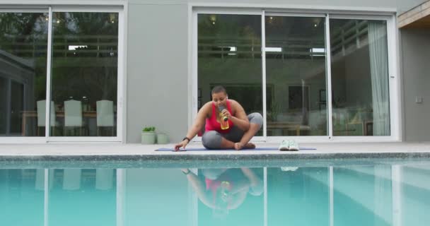 아프리카 미국인 더하기 연습하는 수영장 옆에서 스마트폰으로 수영하는 집에서 여가를 — 비디오