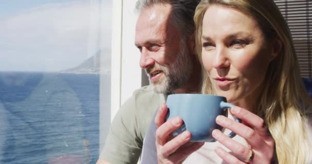 Glückliches Kaukasisches Reifes Paar Das Kaffee Trinkt Und Sonnigen Wohnzimmer — Stockvideo
