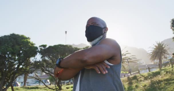 Homem Americano Africano Sênior Vestindo Máscara Facial Exercitando Alongamento Campo — Vídeo de Stock