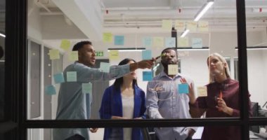 Dört farklı erkek ve kadın meslektaşın gece ofiste fikir alışverişinde bulundukları bir video. İş, iletişim, kapsayıcılık ve dijital olarak oluşturulan esnek çalışma konsepti.