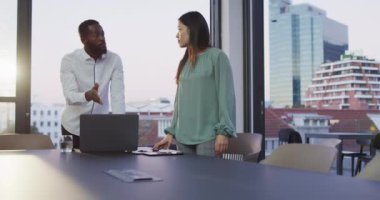 İki farklı erkek ve kadın meslektaşın ofiste dizüstü bilgisayarı tartışırken ve kullanırken videosu. İş, iletişim, kapsayıcılık ve dijital olarak oluşturulan esnek çalışma konsepti.
