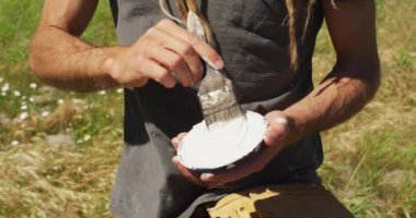 Kafkasyalı erkek ressamın fırçaya boya sürerken videosu. Özgürlük, yaratıcılık, kapsayıcılık ve hobiler dijital olarak oluşturulmuş video konsepti.