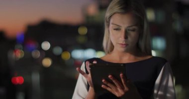 Ofiste gece vakti tablet kullanan düşünceli beyaz iş kadını videosu. İş, iletişim ve esnek çalışma konsepti dijital olarak oluşturulmuş video.
