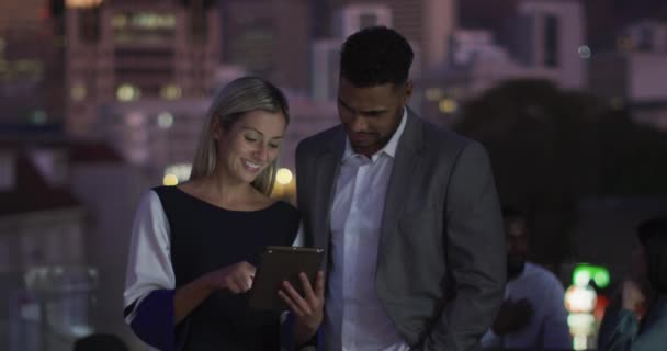 Vídeo Dois Colegas Felizes Diversificados Conversando Usando Tablet Noite Escritório — Vídeo de Stock