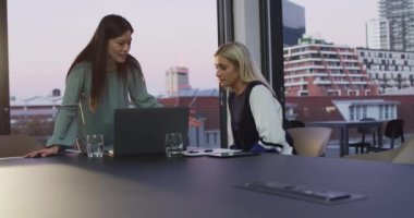 Ofiste dizüstü bilgisayarı tartışan ve kullanan iki farklı bayan meslektaşın videosu. İş, iletişim, kapsayıcılık ve dijital olarak oluşturulan esnek çalışma konsepti.