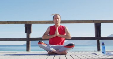 Rastalı, yoga meditasyonu yapan, güneşli, sakin, beyaz bir adamın videosu. Özgürlük, refah ve sağlıklı yaşam tarzı konsepti dijital olarak oluşturulmuş video.