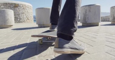 Sahildeki güneşli gezinti güvertesinde kaykay yaparken çekilmiş bir video. Özgürlük, spor, hobiler ve dijital ortamda üretilmiş sağlıklı yaşam tarzı konsepti..