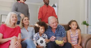 Farklı ailelerin kanepede oturup maç izlediği bir video. Aile hayatı, ailenle vakit geçirmek..