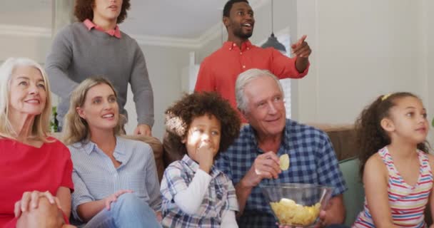 ソファに座ってサッカーの試合を見ている多様な家族のビデオ 家族生活 家族と一緒に時間を過ごす — ストック動画