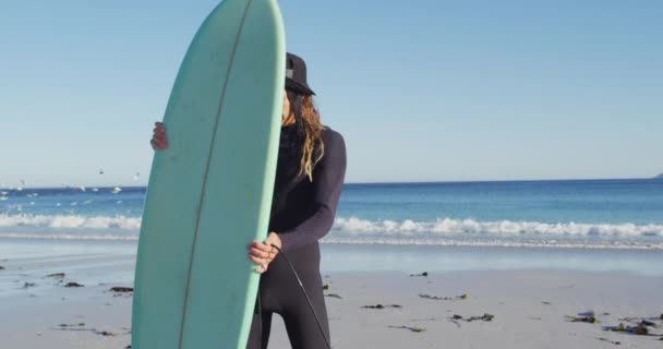 Nagranie Uśmiechniętego Białego Mężczyzny Dredami Kombinezonie Trzymającego Deskę Surfingową Słonecznej — Wideo stockowe