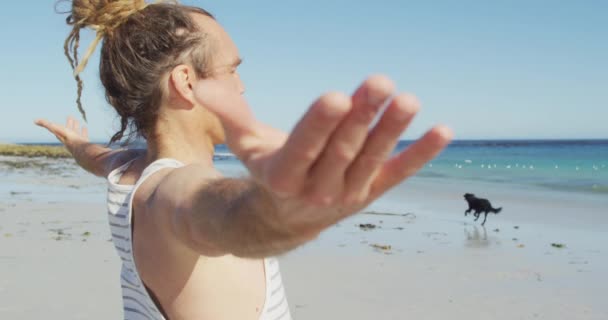 Vídeo Homem Caucasiano Com Dreadlocks Praticando Ioga Praia Ensolarada Com — Vídeo de Stock