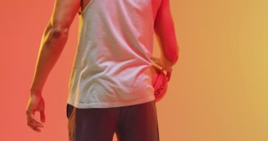 Çift ırklı erkek basketbolcunun turuncudan sarıya zıplayan topun dikiz görüntüsü. Spor ve rekabet konsepti.