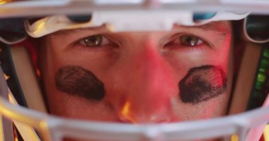 Kafkaslı beyaz amerikalı futbolcunun neon sarısı arka planda yakın çekim videosu. Amerikan futbolu, spor ve yarışma konsepti.