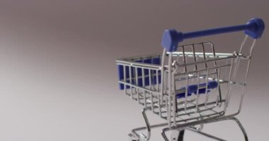 Gri arka planda boş mavi alışveriş arabası. Alışveriş, satış ve perakende konsepti dijital olarak oluşturuldu.