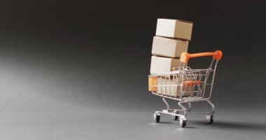 Dikensiz, fotokopi alanı olan siyah arkaplan üzerine karton kutular yığılmış alışveriş arabaları. Kara Cuma, alışveriş, satış ve perakende konsepti dijital olarak oluşturulmuş video.