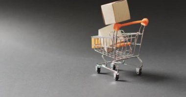 Karton kutularla dolu alışveriş arabaları, kusursuz, fotokopi alanı ile aydınlatılmış siyah arka planlar. Kara Cuma, alışveriş, satış ve perakende konsepti dijital olarak oluşturulmuş video.