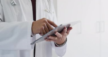 Melez erkek doktorun tablet kullanırken görüntüsü. Tıbbi hizmetler, iletişim, teletıp, sağlık ve kapsayıcılık kavramı.