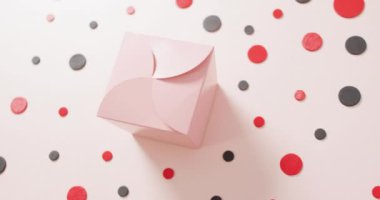 Kırmızı ve siyah noktalı beyaz arka planda pembe hediye kutusu manzarası. Lüks muamele, mevcut, alışveriş, satış ve perakende konsepti dijital olarak oluşturulmuş video.