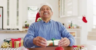 Noel Baba şapkalı, mutlu, çift ırklı bir adamın Noel videosu. Kameraya gülümsüyor. Noel, gelenek, küresel iletişim, kapsayıcılık ve kıdemli yaşam tarzı konsepti.