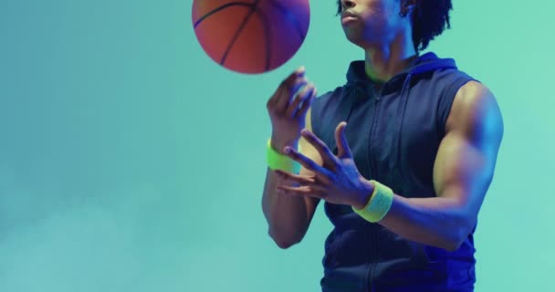 緑色の背景にボールを回転させる出生男性バスケットボール選手のビデオ スポーツ 競技の概念 — ストック動画