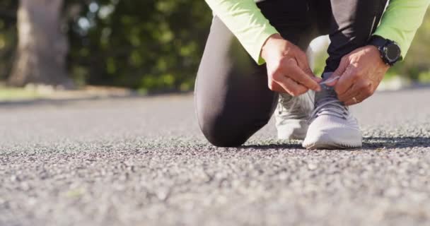 Filmik Niskim Odcinkiem Starszego Mężczyzny Sportowej Odzieży Klęczącego Ulicznych Sznurowadłach — Wideo stockowe