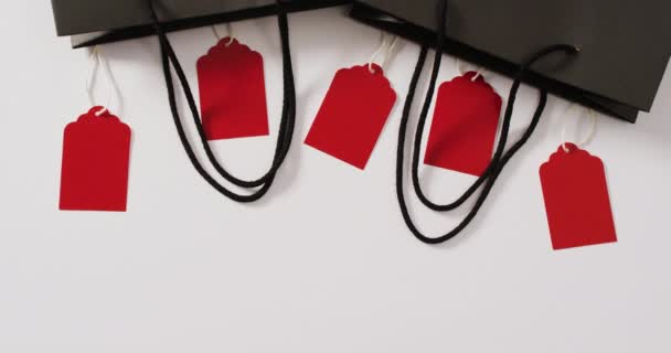 两个黑色礼品袋 五个红色销售标签 白色背景 有复制空间 奢侈品处理 黑色星期五销售和零售概念数字生成视频 — 图库视频影像