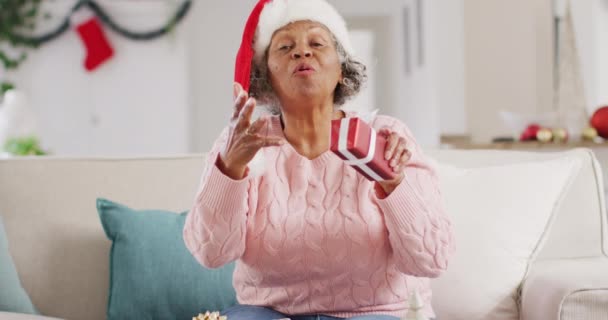快乐的资深非洲裔美国女人戴着圣塔克洛斯帽 在圣诞节有视频拜访 在家里度过时间和圣诞节的概念 — 图库视频影像