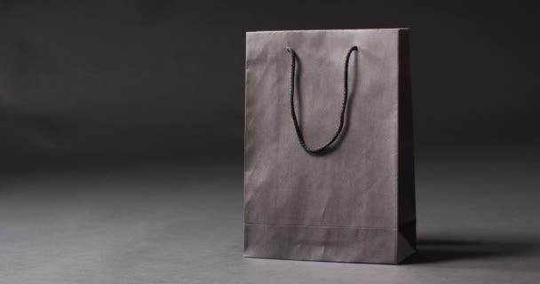 黑色礼品袋 黑色手柄 深灰色背景 复制空间 奢侈品处理 黑色星期五销售和零售概念数字生成视频 — 图库视频影像