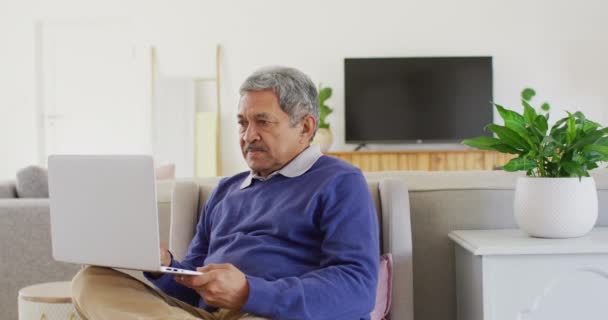 Video Bahagia Biracial Man Senior Menggunakan Laptop Duduk Ruang Tamu — Stok Video