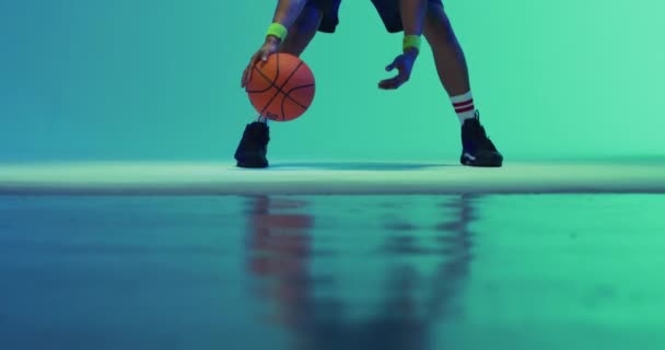 緑色から青色の背景にボールを跳ねる出生男性バスケットボール選手のビデオ スポーツ 競技の概念 — ストック動画