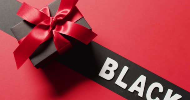黑色星期五文本白色在黑色条纹和黑色礼品盒与红丝带 红色背景 奢侈品处理 黑色星期五销售和零售概念数字生成视频 — 图库视频影像