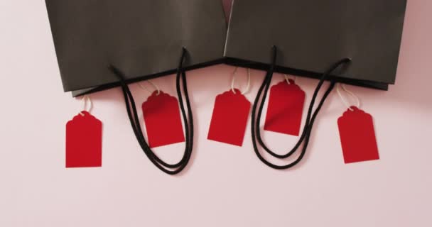 两个黑色礼品袋 五个红色销售标签 白色背景 有复制空间 奢侈品处理 黑色星期五销售和零售概念数字生成视频 — 图库视频影像