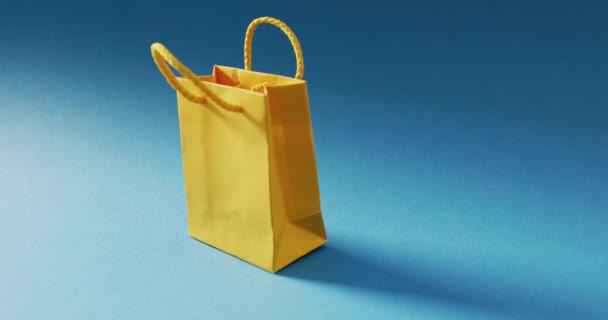 Bolsa Regalo Amarilla Con Asa Cuerda Fondo Azul Compras Venta — Vídeos de Stock