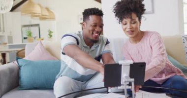Mutlu Afro-Amerikan çift oturma odasında birlikte tablet kullanıyor. Evde birlikte vakit geçirmek kavramı..