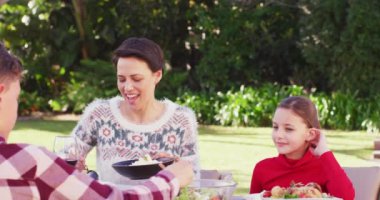 Kafkasyalı mutlu bir aile bahçede yemek yiyor. Ev kavramında aileyle kaliteli zaman geçirmek.