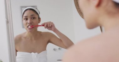 Bandoda diş fırçalayan çift ırklı bir kadın. Güzellik, sağlık ve kadın spa konsepti.