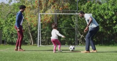 Mutlu Afro-Amerikan ailesi parkta futbol oynuyor. Aileyle açık hava konsepti ile kaliteli zaman geçirmek.