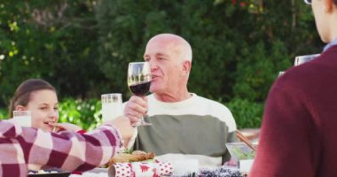 Kafkasyalı mutlu bir aile bahçede yemek yiyor. Ev kavramında aileyle kaliteli zaman geçirmek.